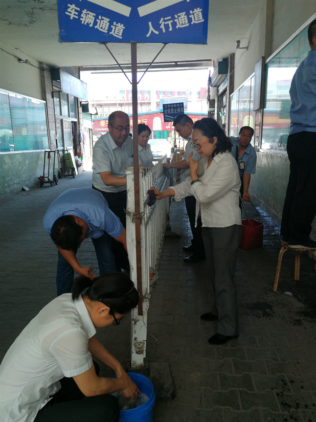 1564546249608654.jpg 圖為:農(nóng)貿(mào)市場管理人員在清洗欄桿_副本.jpg